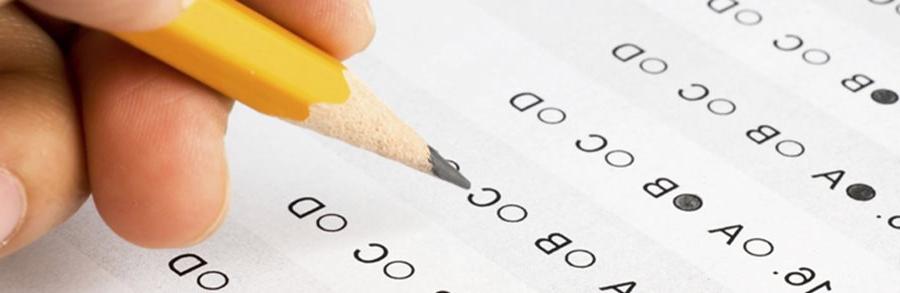 Student filling out multiple choice scantron answer sheet